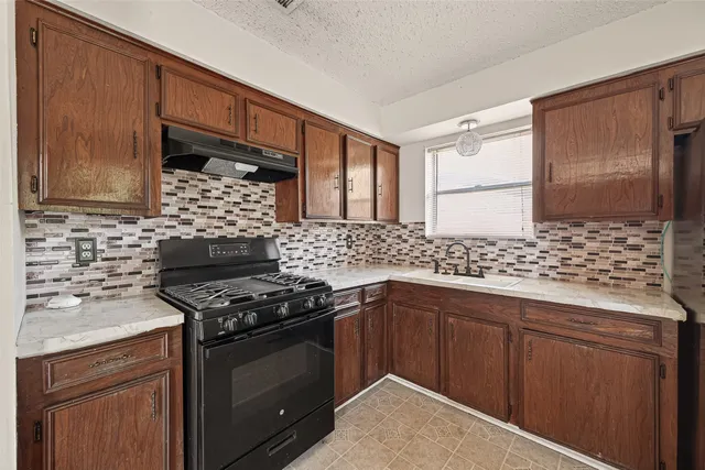 a kitchen with stainless steel appliances a stove and a sink