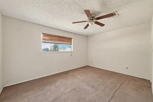 a view of a big room with a ceiling fan and a window