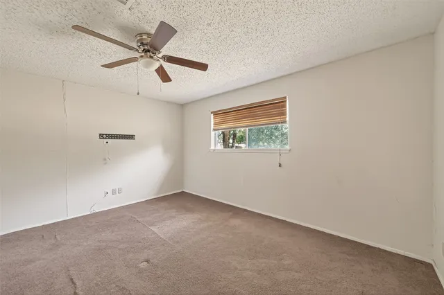 an empty room with a window and a fan