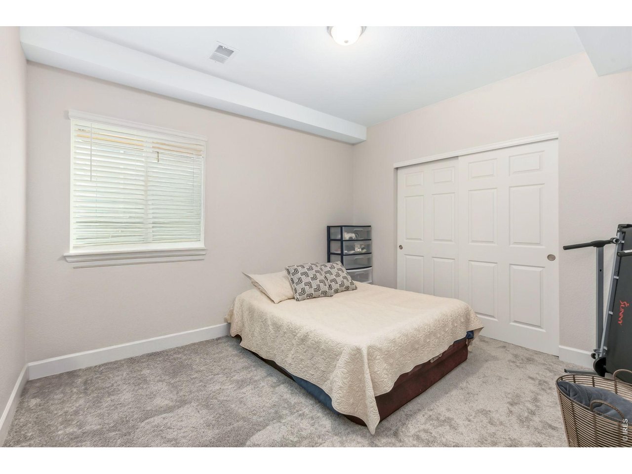 955 Rustling Street Windsor, CO 80550 - Photo 28 of 34 a bedroom with a bed and a flat tv screen on the dresser