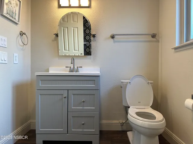 a bathroom with a toilet sink and mirror