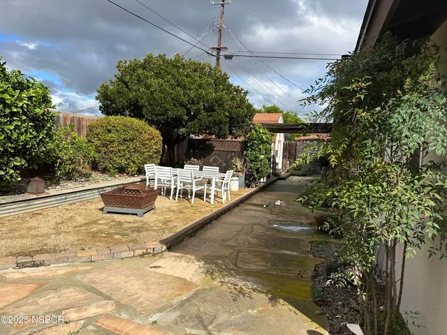 a view of a patio with chairs and potted plants