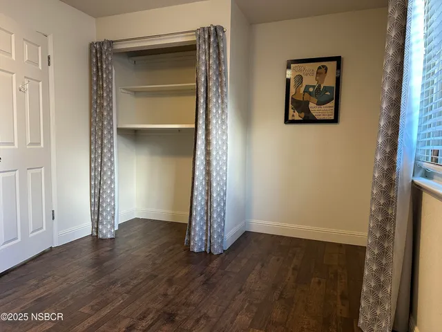 an empty room with wooden floor and closet