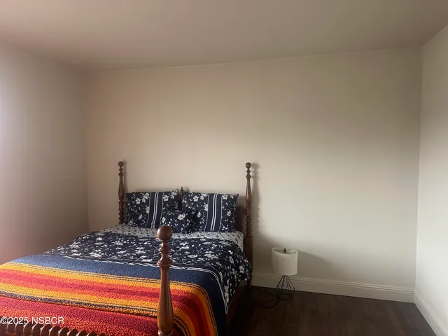 a bedroom with a bed and a lamp on the dresser