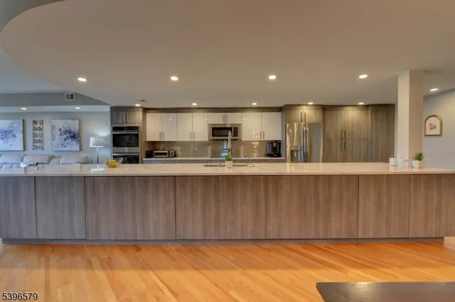 a large kitchen with kitchen island a sink a counter top space and stainless steel appliances