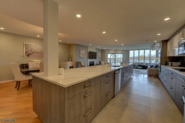 a large kitchen with stainless steel appliances a large counter top a stove and a refrigerator