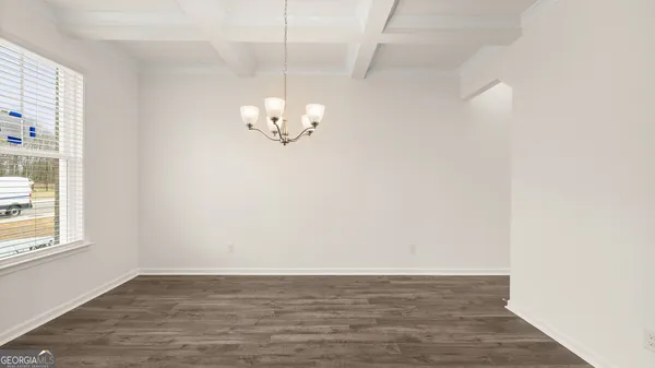 a dining room with wooden floor and chandelier
