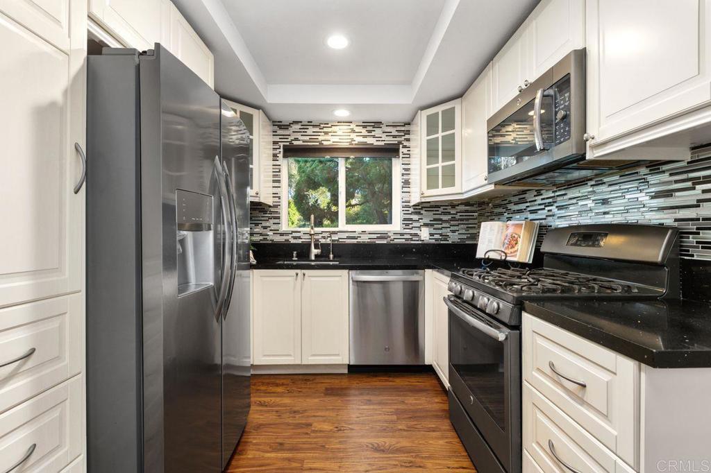 4369 Dowitcher Way Oceanside, CA 92057 - Photo 12 of 37 a kitchen with stainless steel appliances granite countertop a refrigerator a stove and a sink