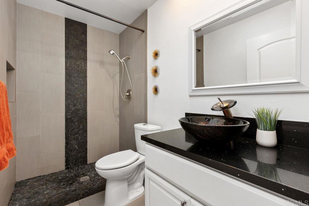 4369 Dowitcher Way Oceanside, CA 92057 - Photo 18 of 37 a bathroom with a granite countertop sink and a toilet