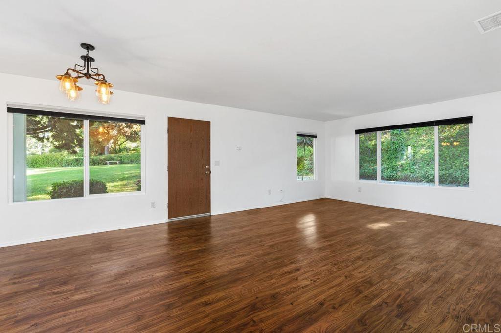 4369 Dowitcher Way Oceanside, CA 92057 - Photo 8 of 37 a view of an empty room with wooden floor and a window