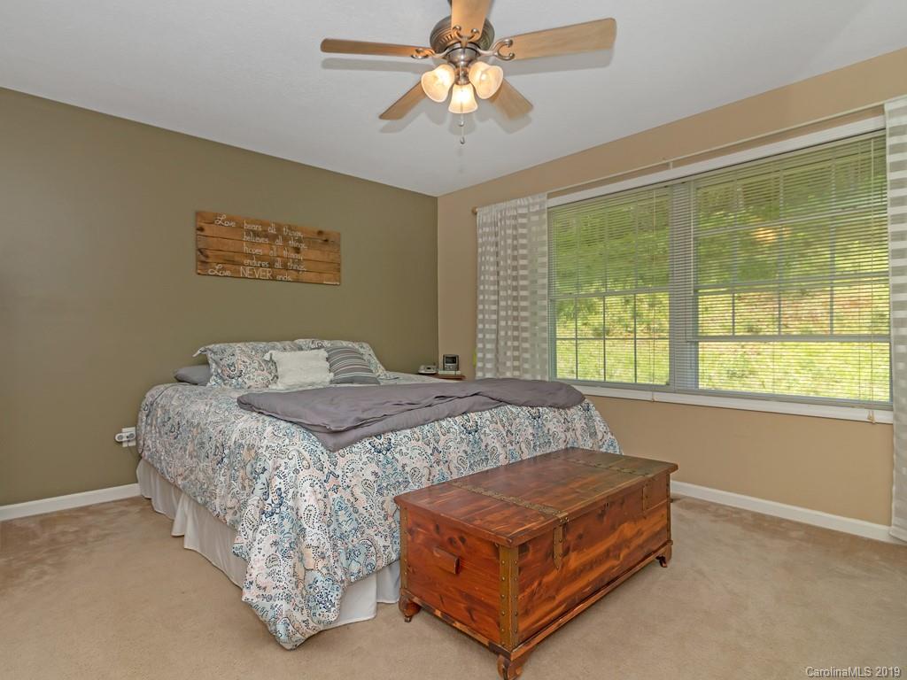 315 Garren Creek Road Rosman, NC 28772 - Photo 13 of 36 a bedroom with a bed and a chandelier