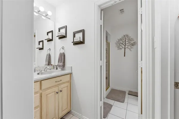 a bathroom with a granite countertop sink a mirror and a shower