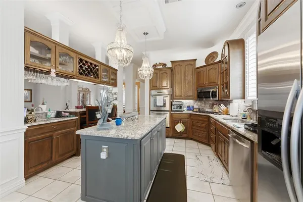 a kitchen with stainless steel appliances granite countertop a sink a stove and a refrigerator