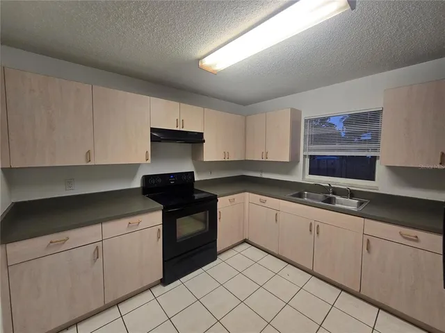 a kitchen with granite countertop white cabinets and black appliances