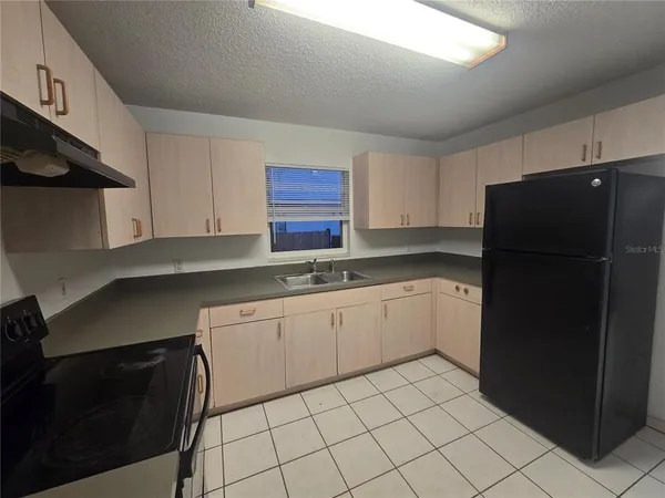 a kitchen with a refrigerator and a sink