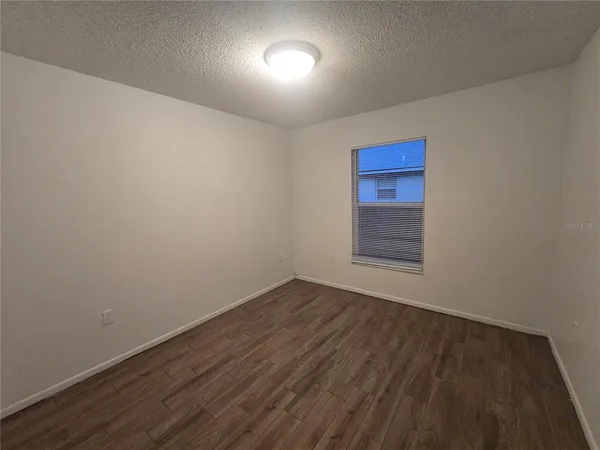 a view of an empty room and wooden floor