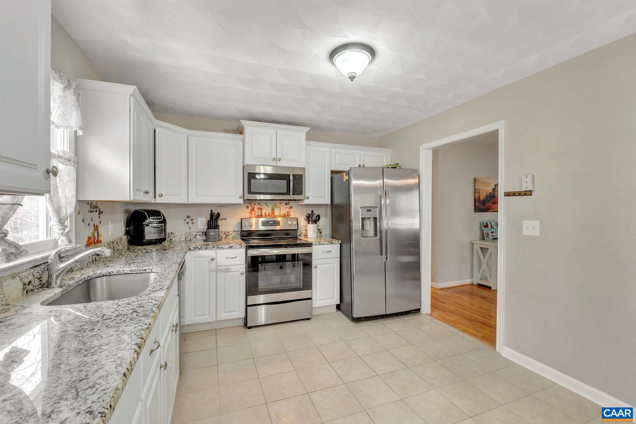 47 Dandelion Road Ruckersville, VA 22968 - Photo 11 of 35 a kitchen with granite countertop a refrigerator and a stove top oven