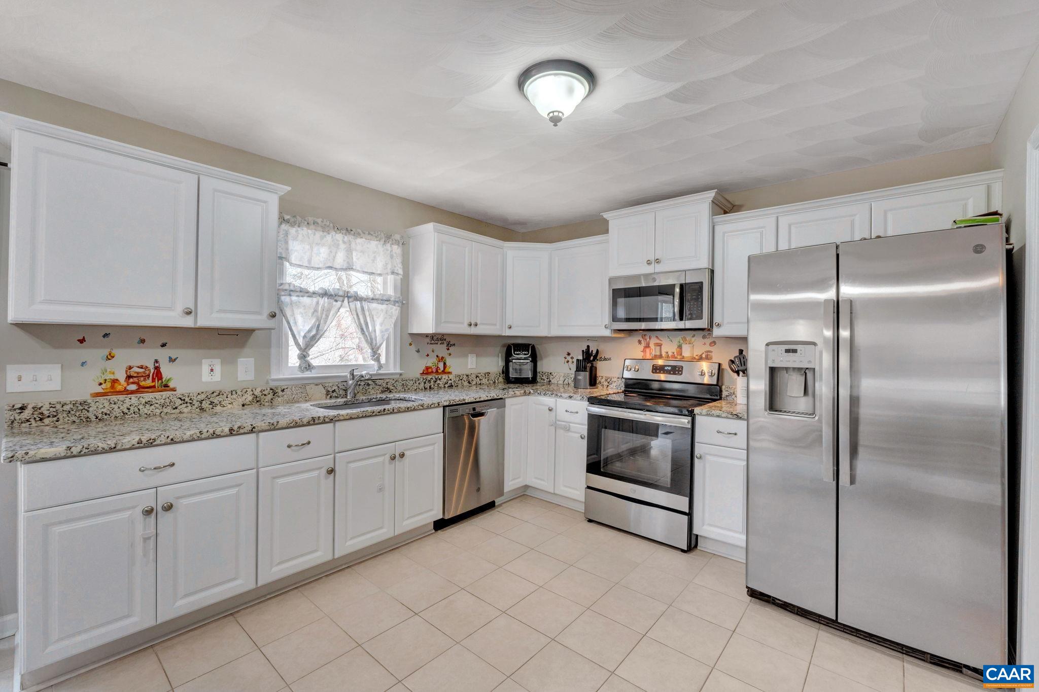 47 Dandelion Road Ruckersville, VA 22968 - Photo 8 of 35 a kitchen with granite countertop white cabinets and stainless steel appliances