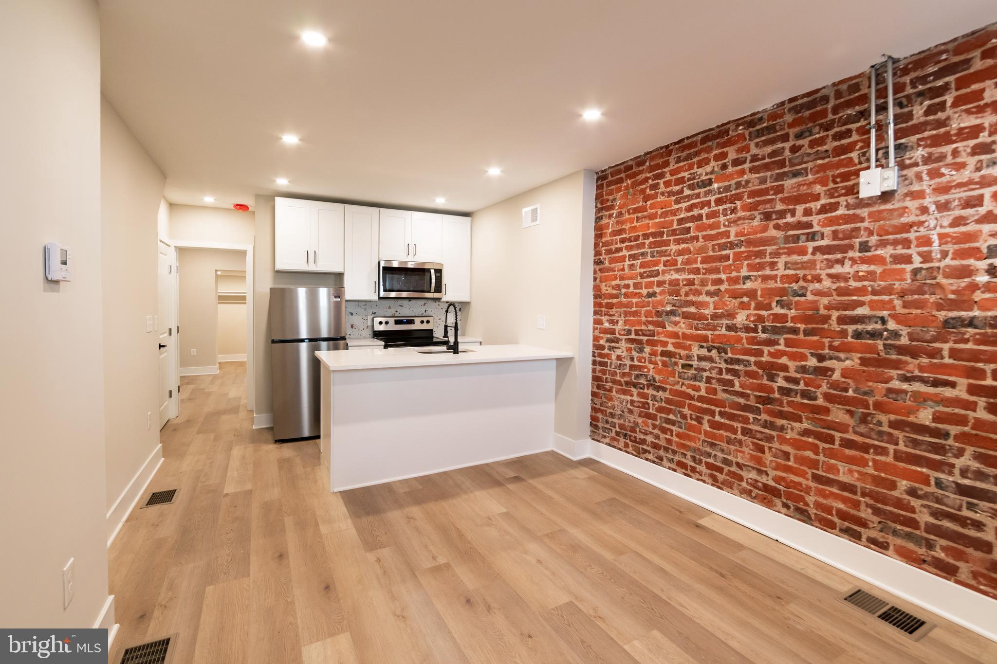 1844 South 23rd Street, Unit 1F Philadelphia, PA 19145 - Photo 2 of 21 a kitchen with stainless steel appliances a refrigerator and a stove top oven
