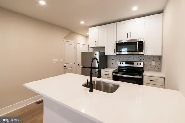 a kitchen with granite countertop a sink and steel appliances