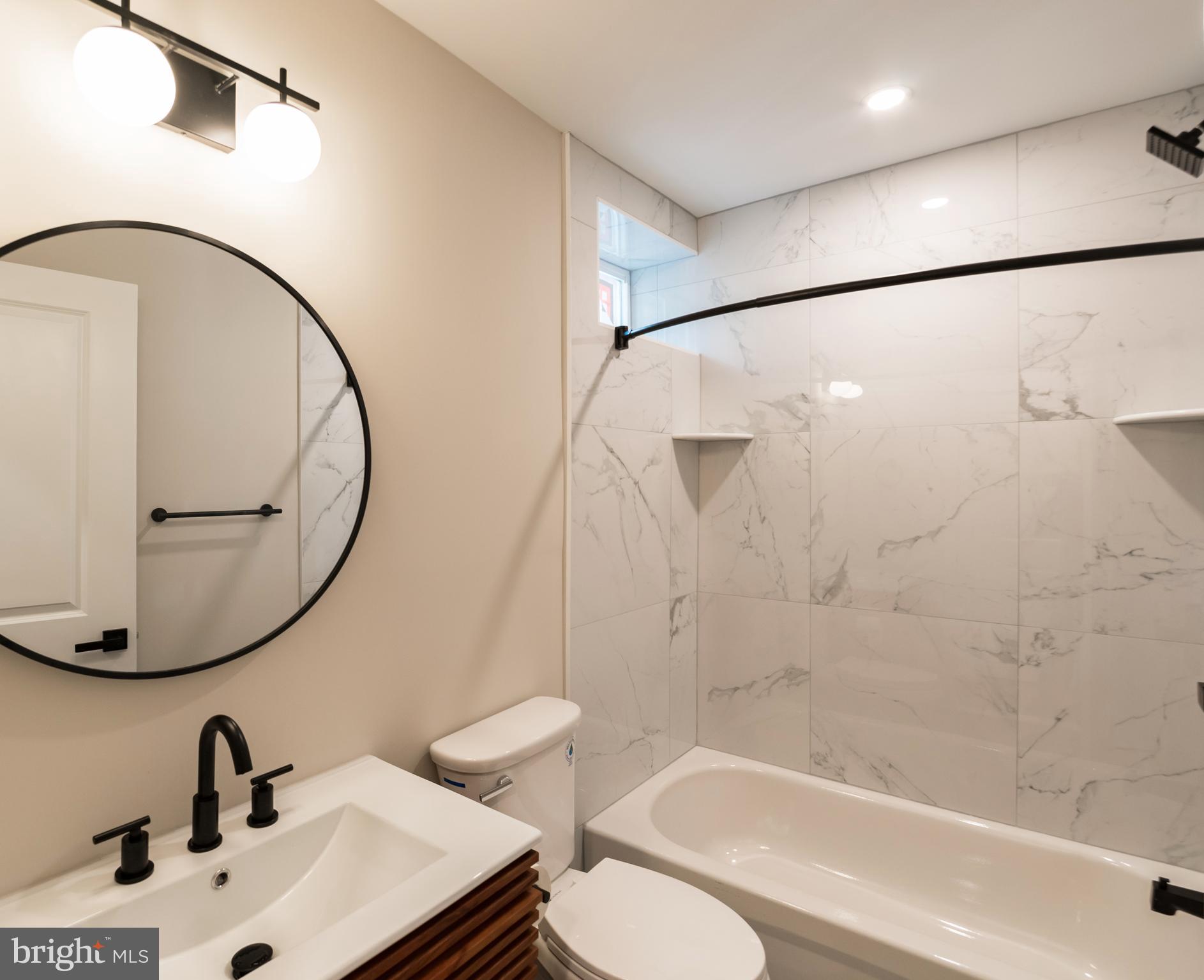 1844 South 23rd Street, Unit 1F Philadelphia, PA 19145 - Photo 7 of 21 a bathroom with a sink a toilet and a mirror