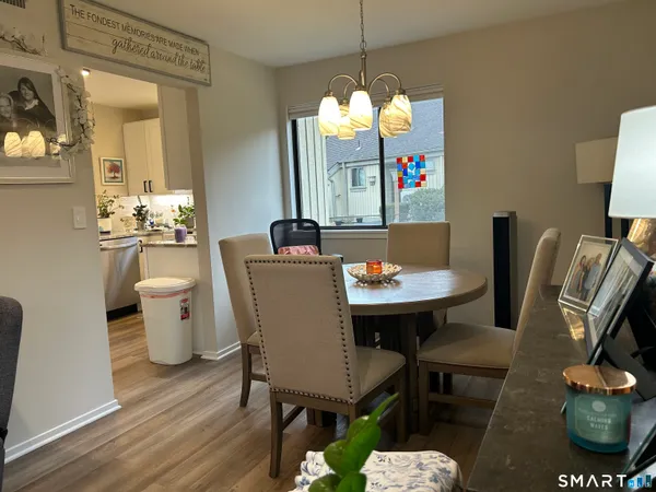 a view of a dining room with furniture a chandelier and wooden floor