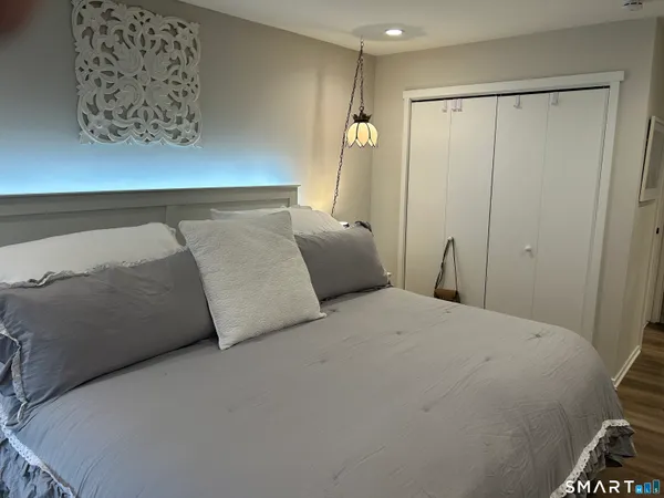 a bedroom with a bed and a painting on the wall
