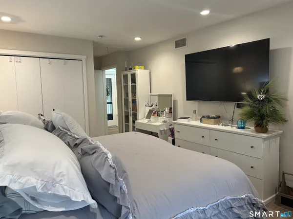 a bedroom with a bed and a flat screen tv
