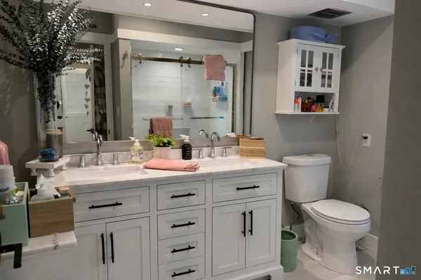 a bathroom with a sink a toilet and a mirror