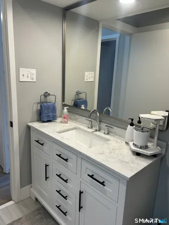 a bathroom with a granite countertop sink and a mirror