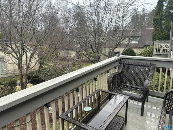 a balcony with wooden floor and outdoor seating