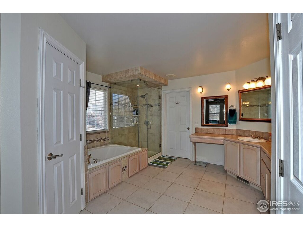 126 52nd Avenue Greeley, CO 80634 - Photo 12 of 24 a bathroom with a granite countertop sink a large mirror and shower
