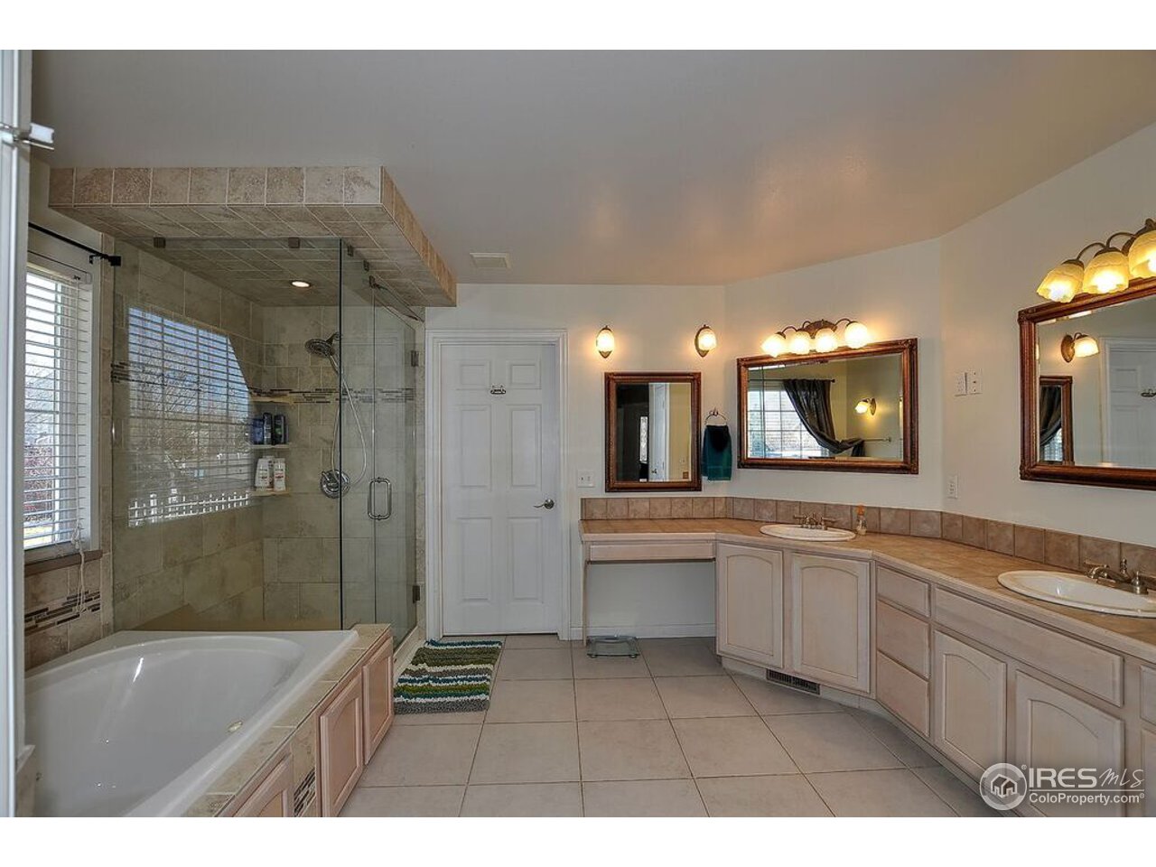 126 52nd Avenue Greeley, CO 80634 - Photo 13 of 24 a bathroom with a sink a large mirror and a bathtub