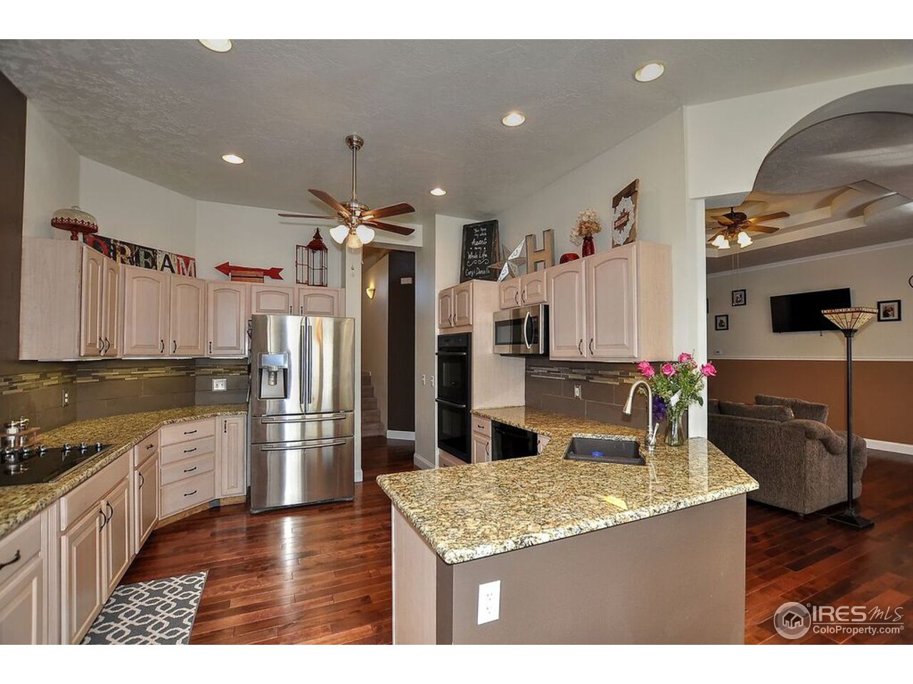 126 52nd Avenue Greeley, CO 80634 - Photo 7 of 24 a kitchen with stainless steel appliances granite countertop a sink refrigerator and cabinets