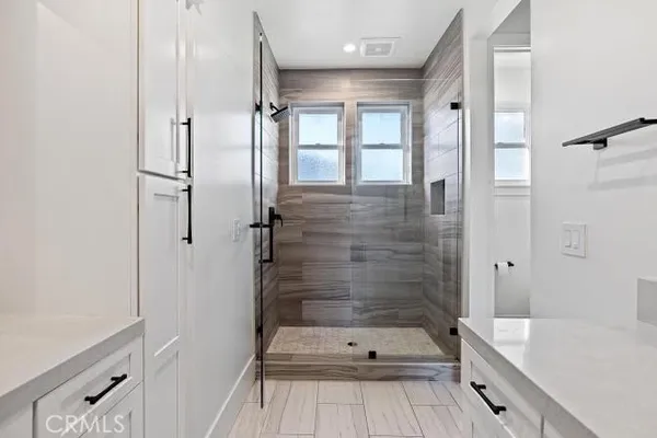 a bathroom with a tub shower vanity and a sink