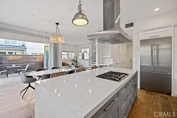 a kitchen with stainless steel appliances a stove a sink dishwasher and white cabinets with wooden floor