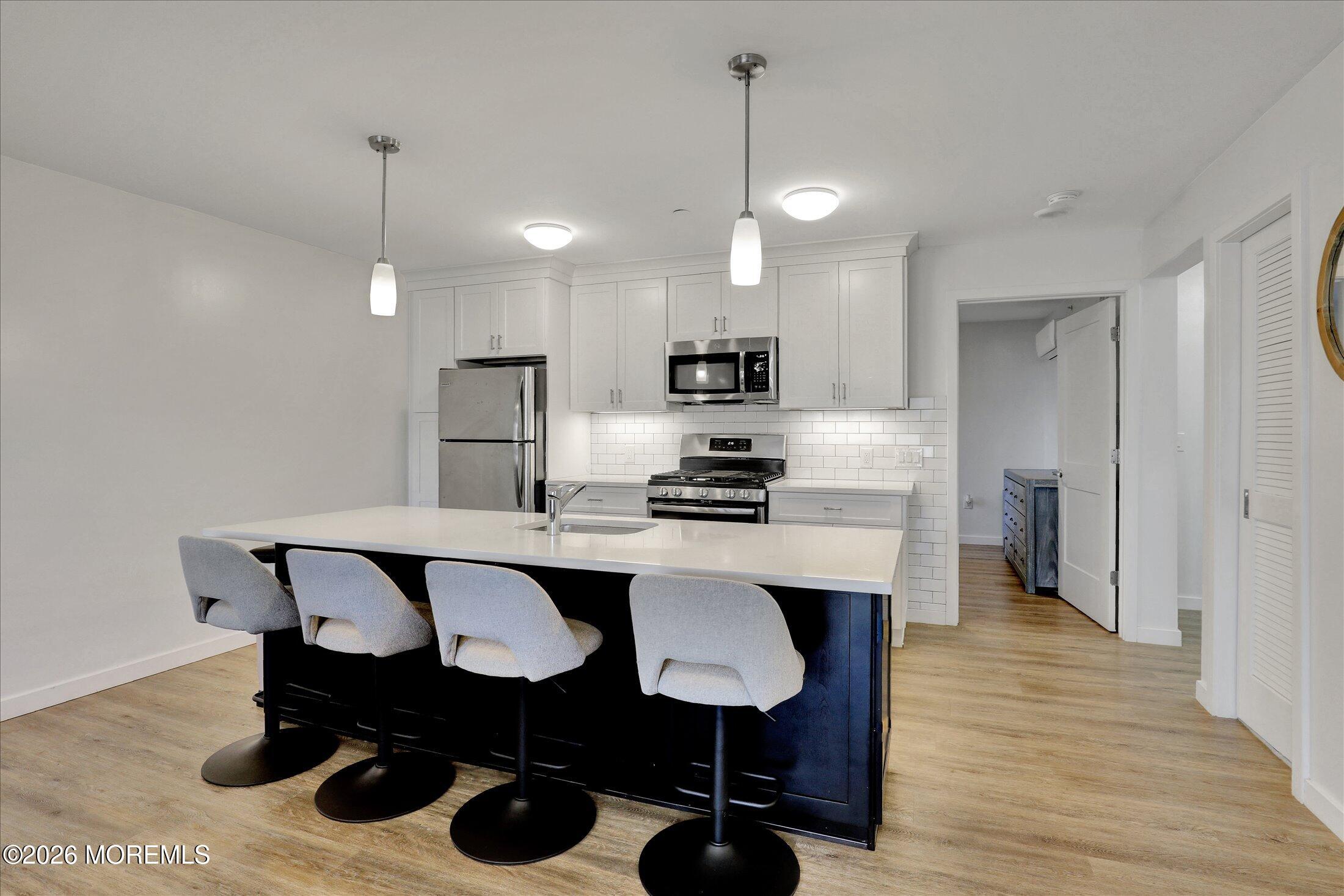 55 Brighton Avenue, Unit 4 Long Branch, NJ 07740 - Photo 1 of 36 a kitchen with stainless steel appliances a dining table chairs refrigerator and sink