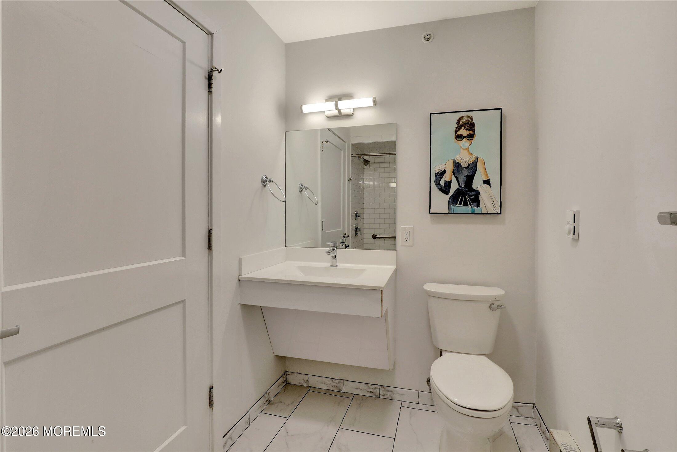 55 Brighton Avenue, Unit 4 Long Branch, NJ 07740 - Photo 23 of 36 a bathroom with a toilet sink and mirror