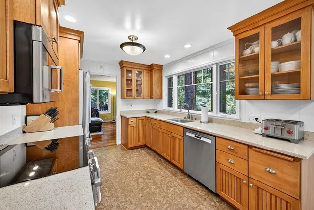a large kitchen with stainless steel appliances granite countertop a sink and cabinets