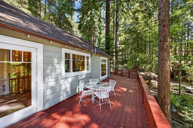 a view of a patio with table and chairs with wooden floor and fence
