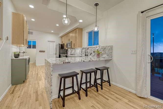12365 Point Reyes Drive Peyton, CO 80831 - Photo 11 of 44 a kitchen with kitchen island a dining table chairs sink and cabinets