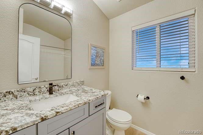 12365 Point Reyes Drive Peyton, CO 80831 - Photo 18 of 44 a bathroom with a granite countertop sink toilet and mirror