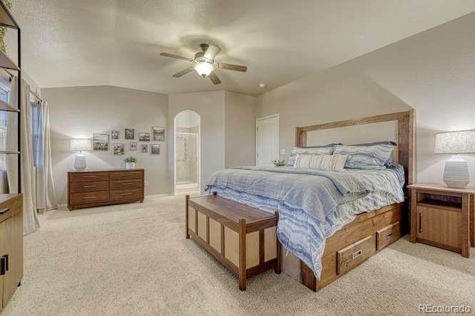 12365 Point Reyes Drive Peyton, CO 80831 - Photo 19 of 44 a spacious bedroom with a bed a chandelier and dresser