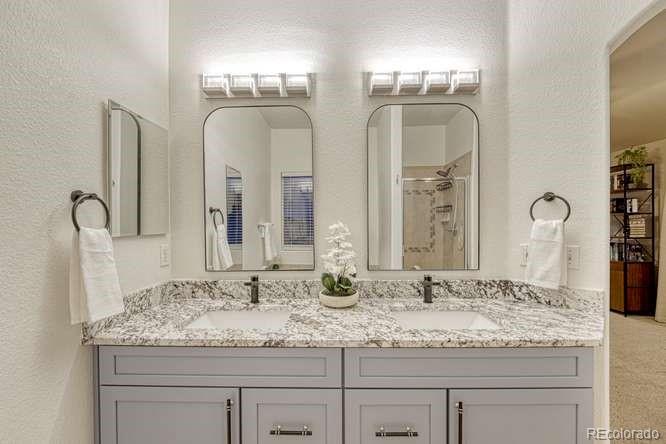 12365 Point Reyes Drive Peyton, CO 80831 - Photo 22 of 44 a bathroom with double vanity sinks and a mirror