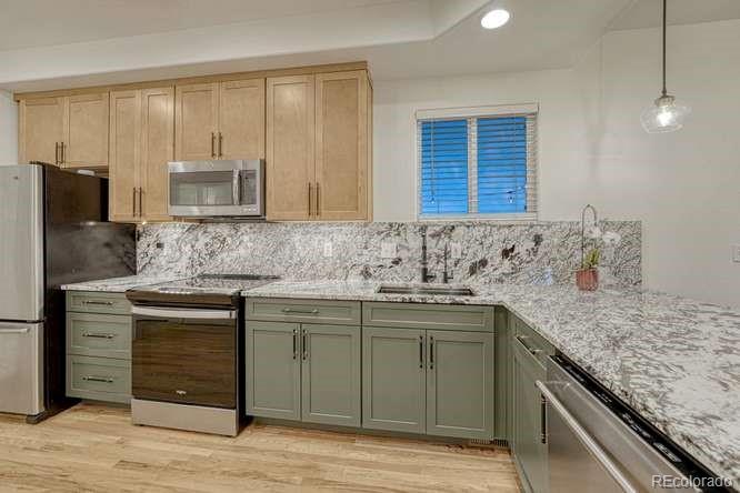 12365 Point Reyes Drive Peyton, CO 80831 - Photo 3 of 44 a kitchen with stainless steel appliances granite countertop a sink stove and refrigerator