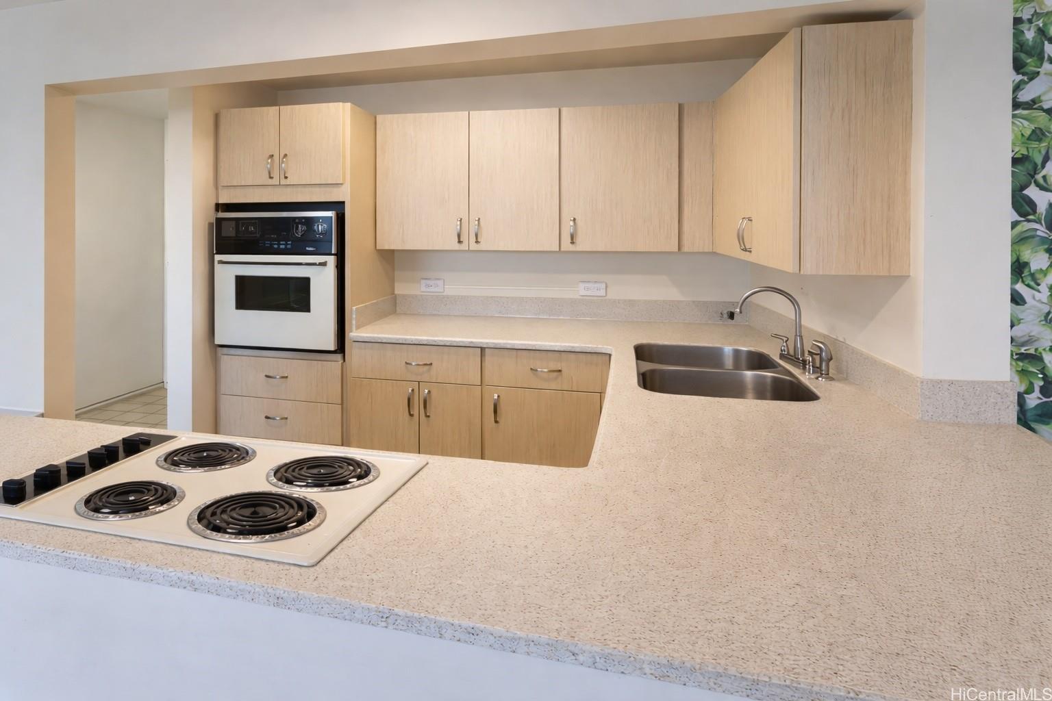 1415 Victoria Street, Unit 906 Honolulu, HI 96822 - Photo 9 of 16 a kitchen with a cabinets and white appliances