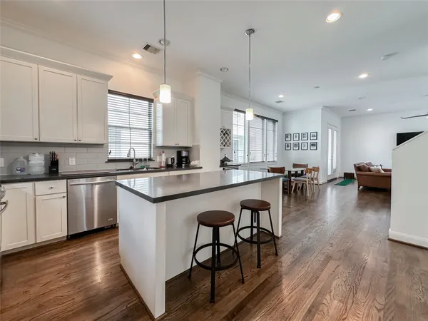 a kitchen with kitchen island white cabinets and stainless steel appliances
