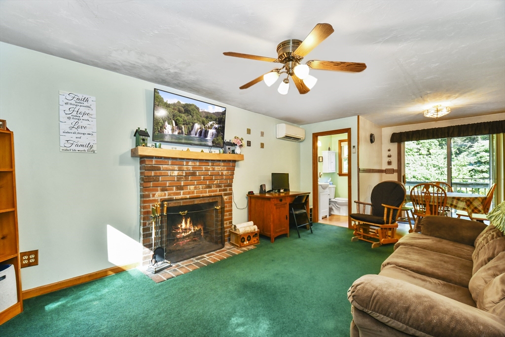 549 Chestnut Hill Road Millville, MA 01529 - Photo 34 of 38 a living room with furniture a fireplace and a flat screen tv
