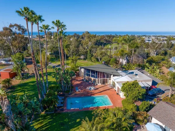 an aerial view of a house with a garden and lake view