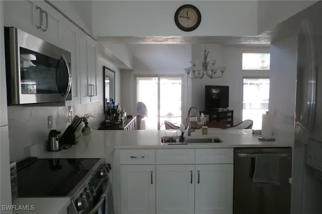 a kitchen with a sink dishwasher refrigerator stove and microwave oven